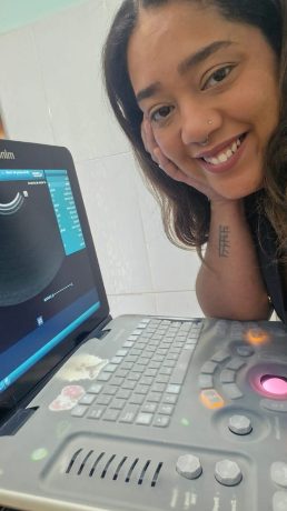 Dra. Karolainy realizando ultrassonografia veterinária com equipamento portátil