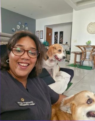Dra. Karolainy de Cassia sorrindo ao lado de dois pets